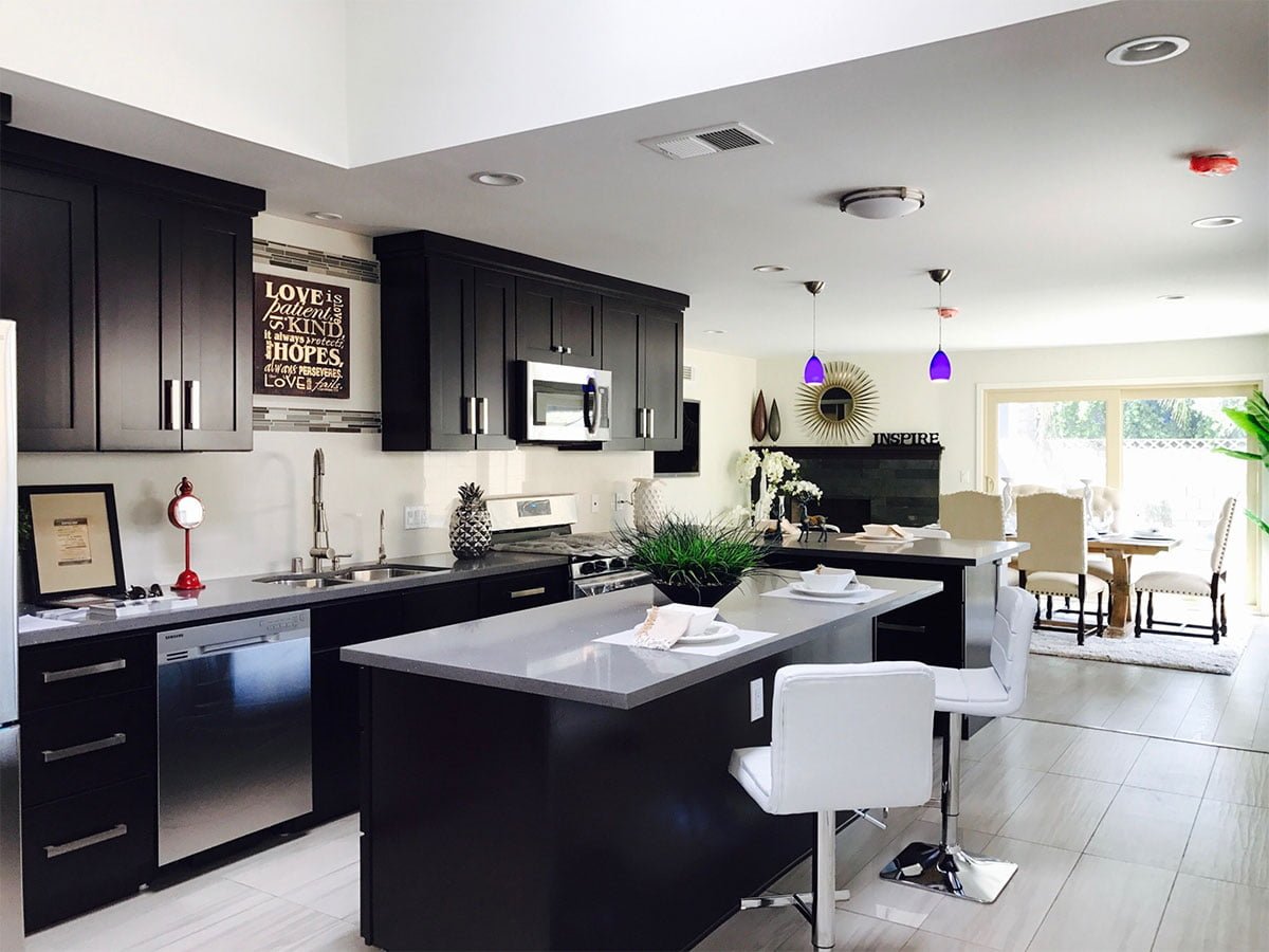 A kitchen with black cabinets and stainless steel appliances.