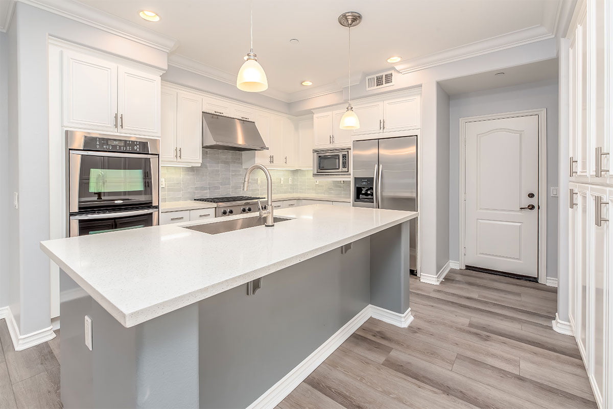 A kitchen with white cabinets and stainless steel appliances.