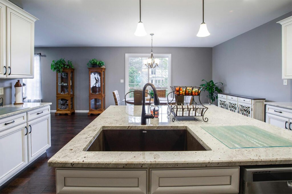 A kitchen with white cabinets and granite counter tops.