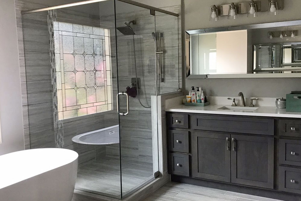 A bathroom with a glass shower stall and sink.