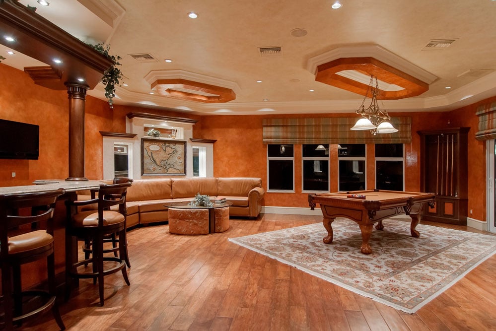 A large living room with a pool table and bar.