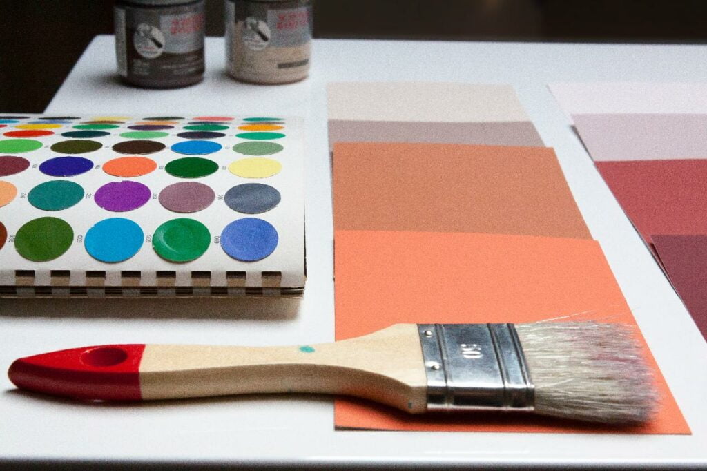 A paint brush next to a paint palette.