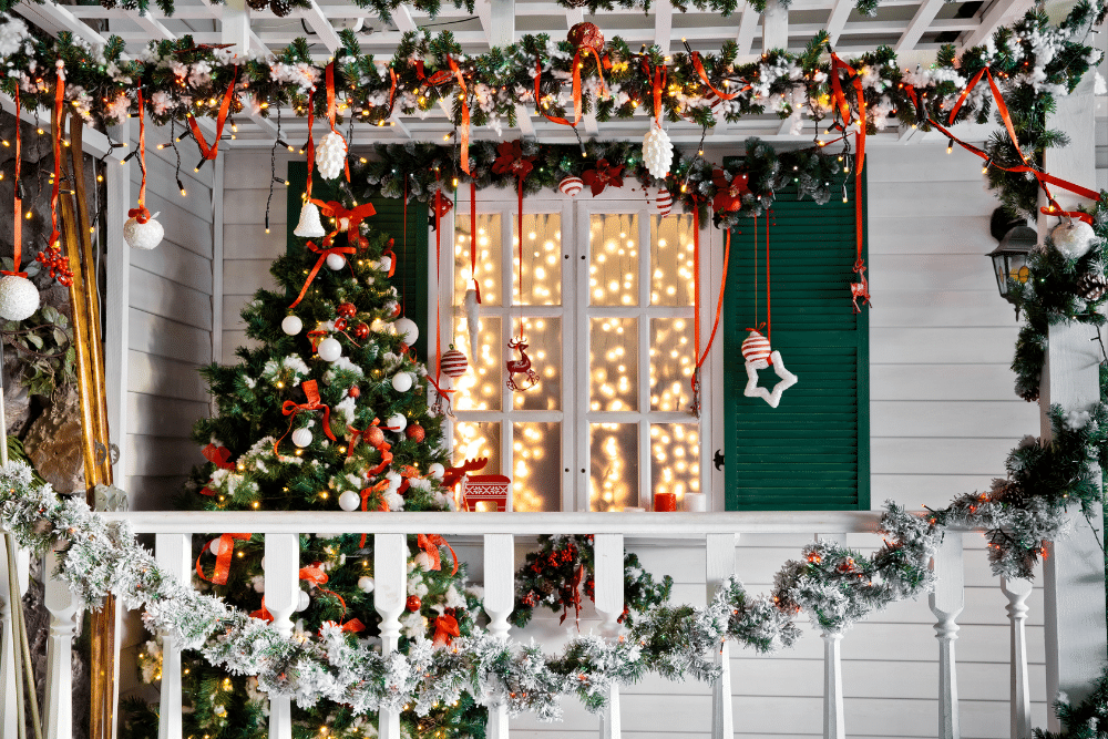 A porch decorated for christmas with a christmas tree and decorations.