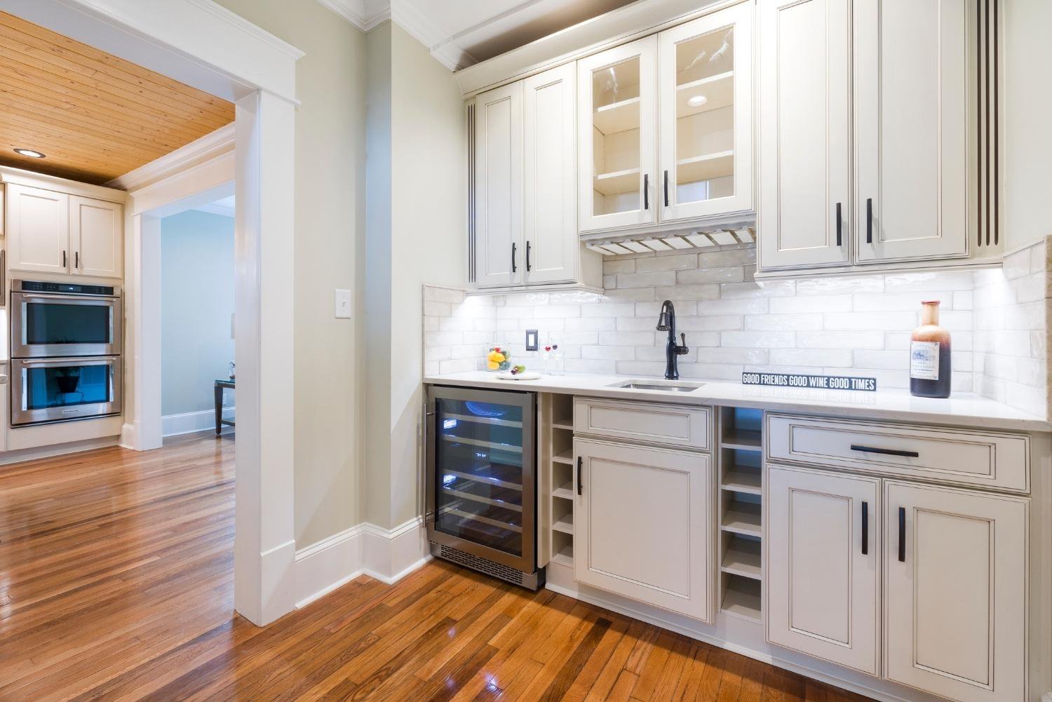 A kitchen with the best white cabinets and a refrigerator.