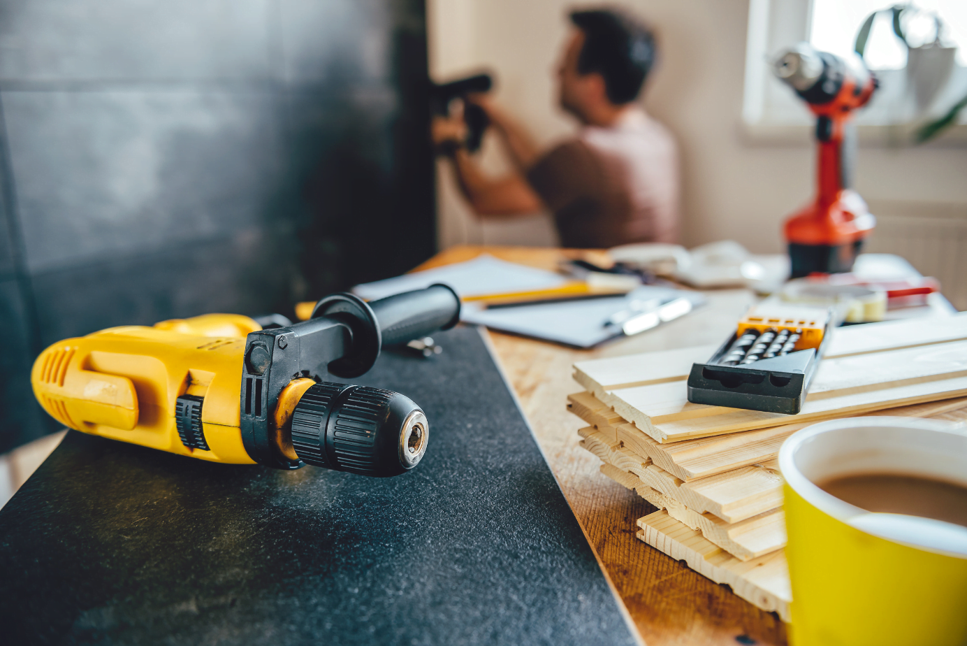 A man is working on a piece of wood with a drill.