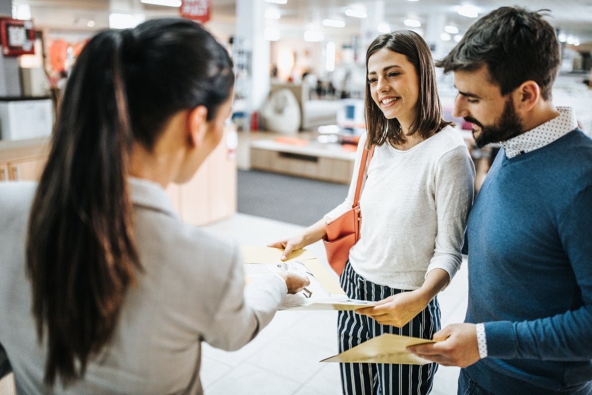 A group of people in a store talking to each other.