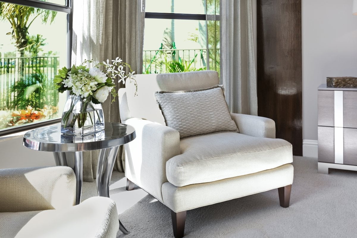 A living room with white furniture and a window.