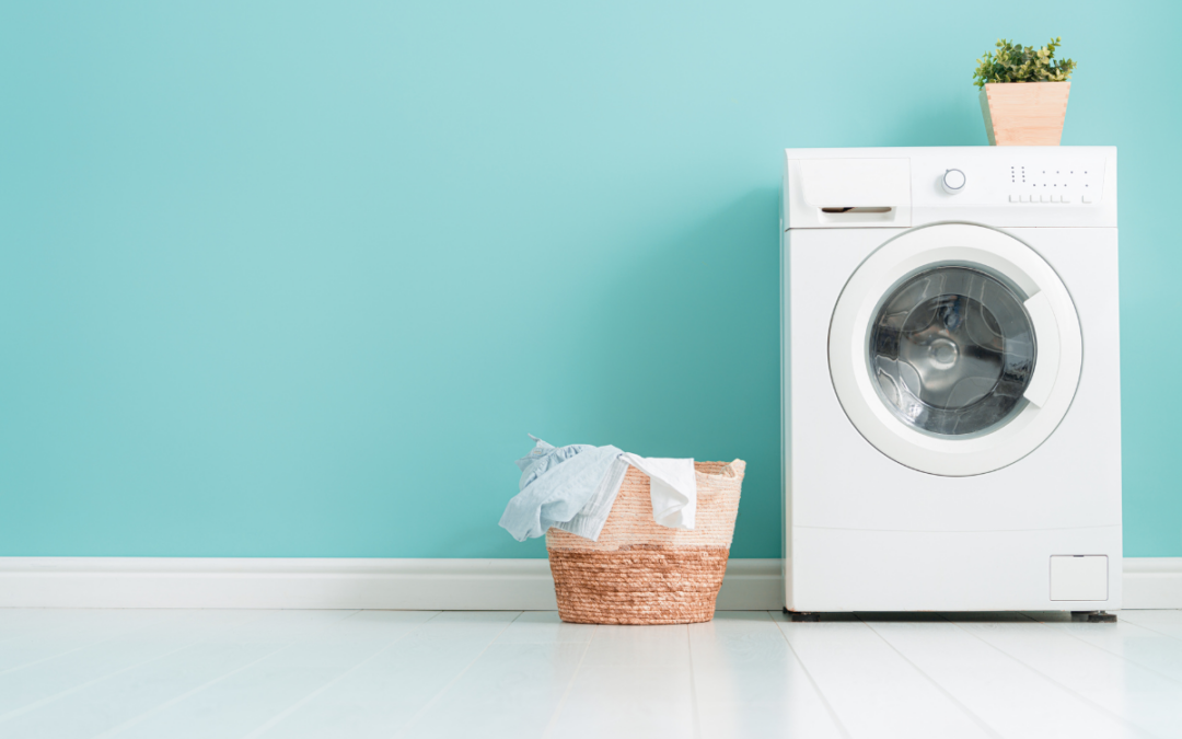 A white washing machine in front of a blue wall, ideal for laundry room layouts.