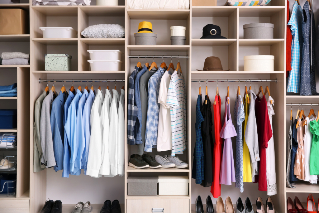 A closet full of clothes and shoes, featuring sliding closet doors.