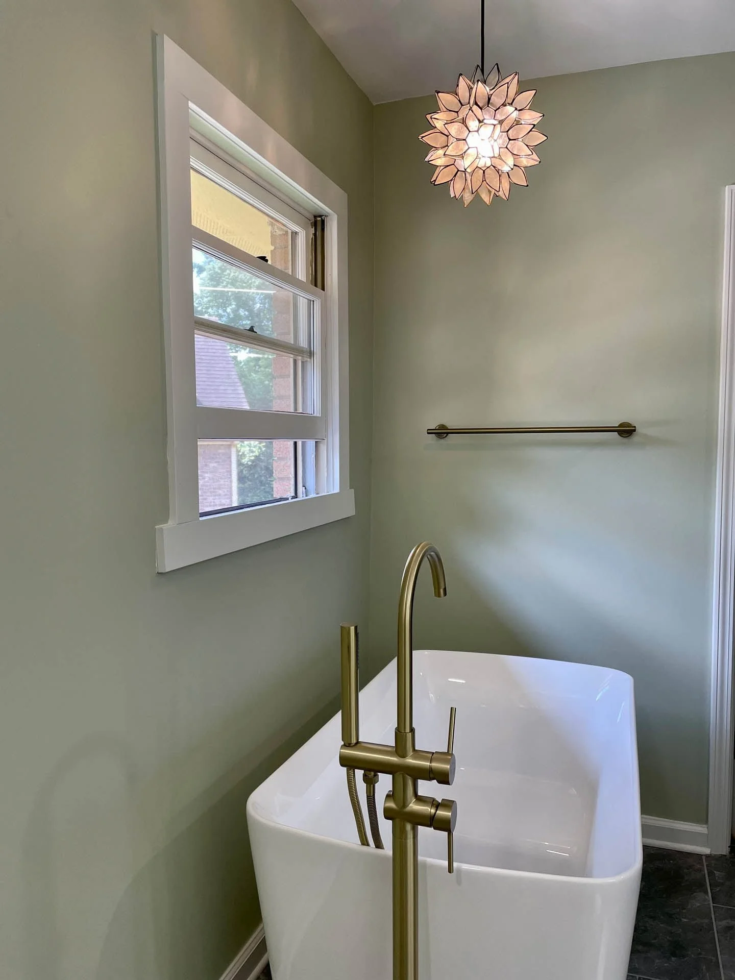 A bathroom with a bathtub and a window.