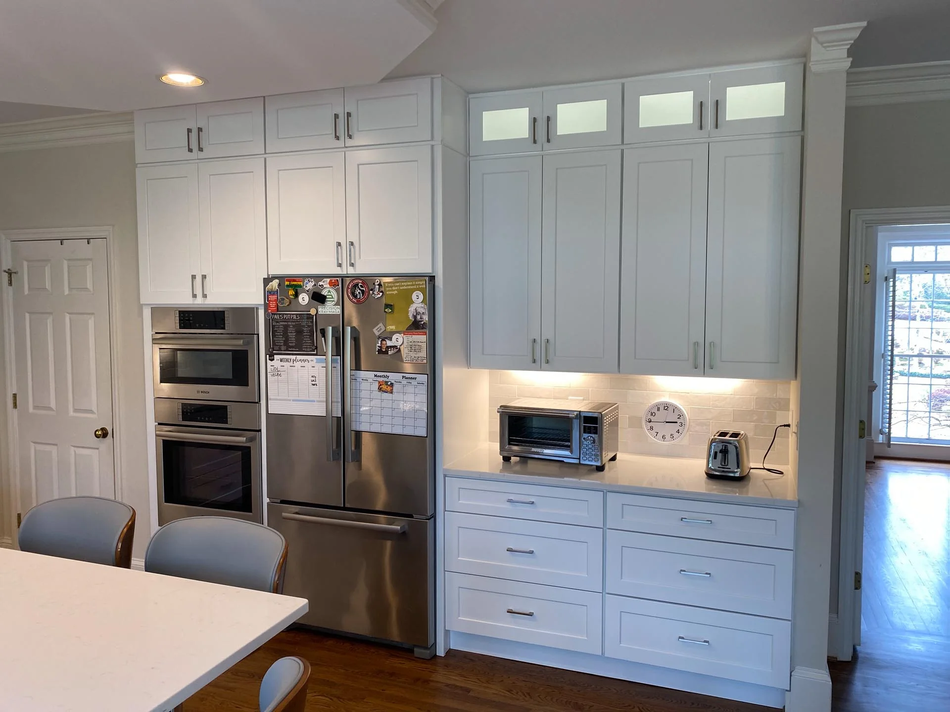 A white kitchen with a table and chairs.