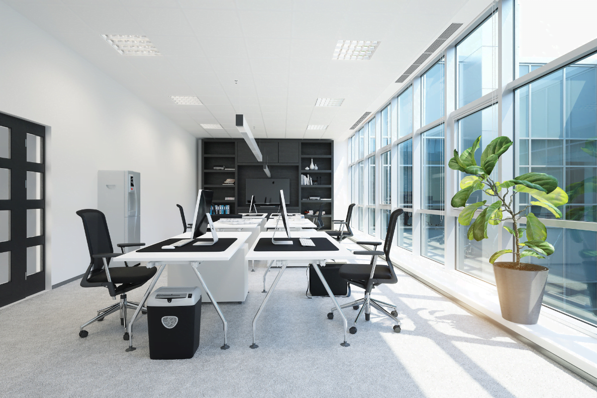 A modern office with large windows and black desks, ready for some commercial remodeling services.