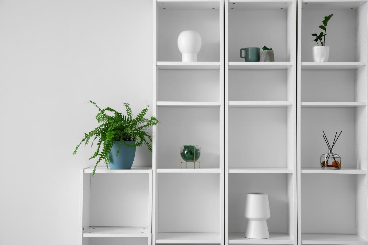 A decorative wall shelf with plants and objects on it.