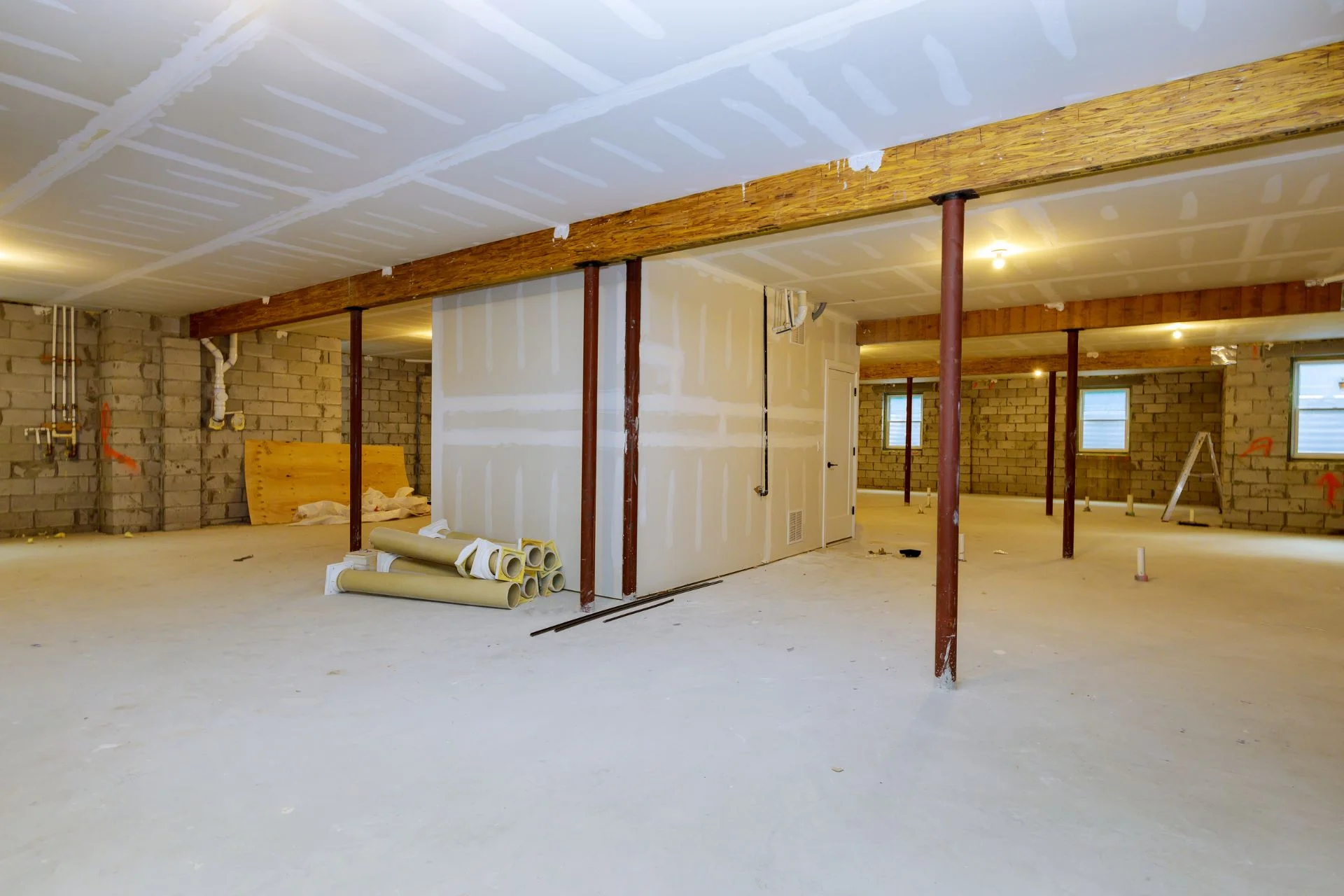 A basement that is being remodeled with wood beams.