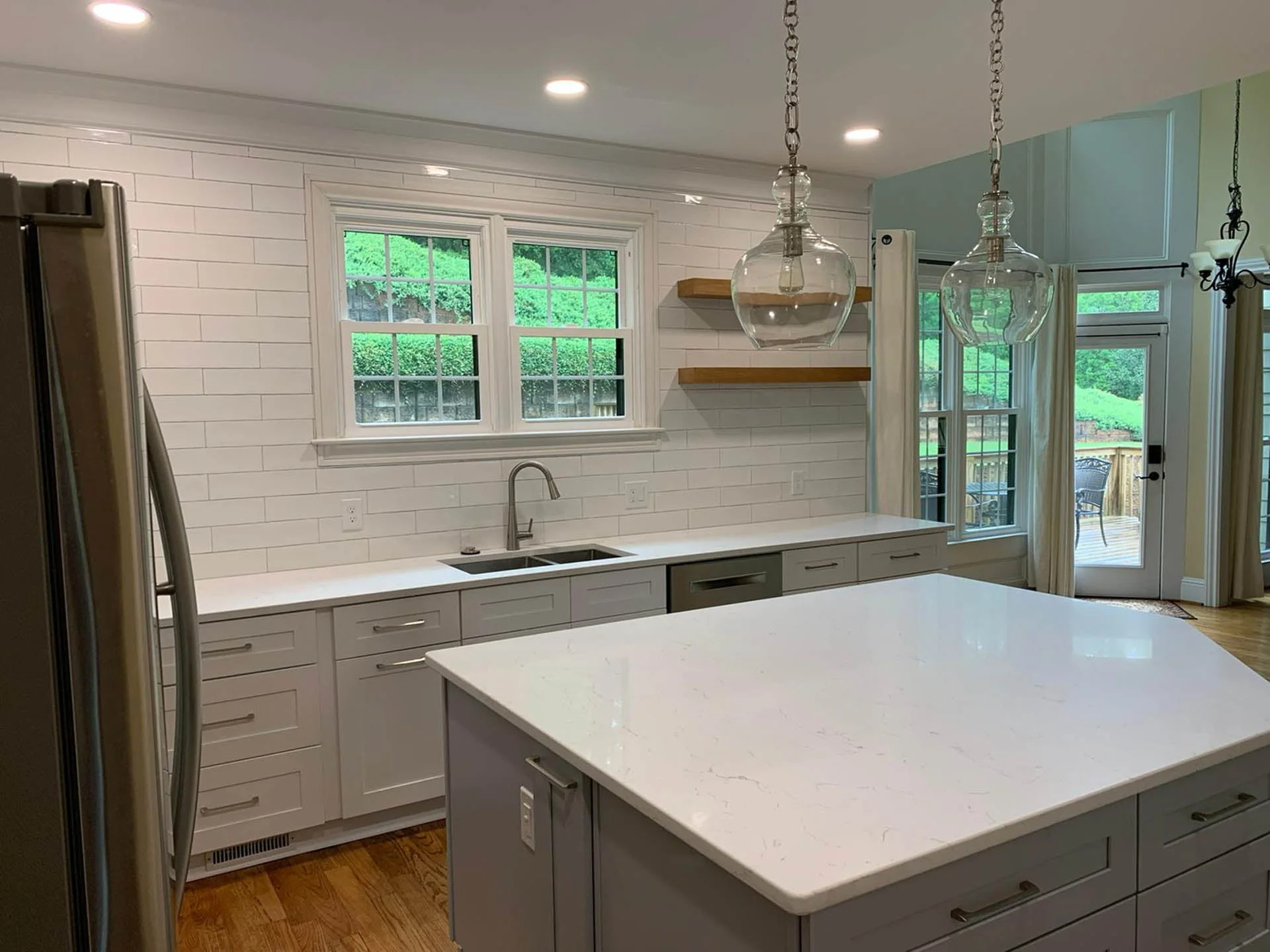 A kitchen with a white island and stainless steel appliances.