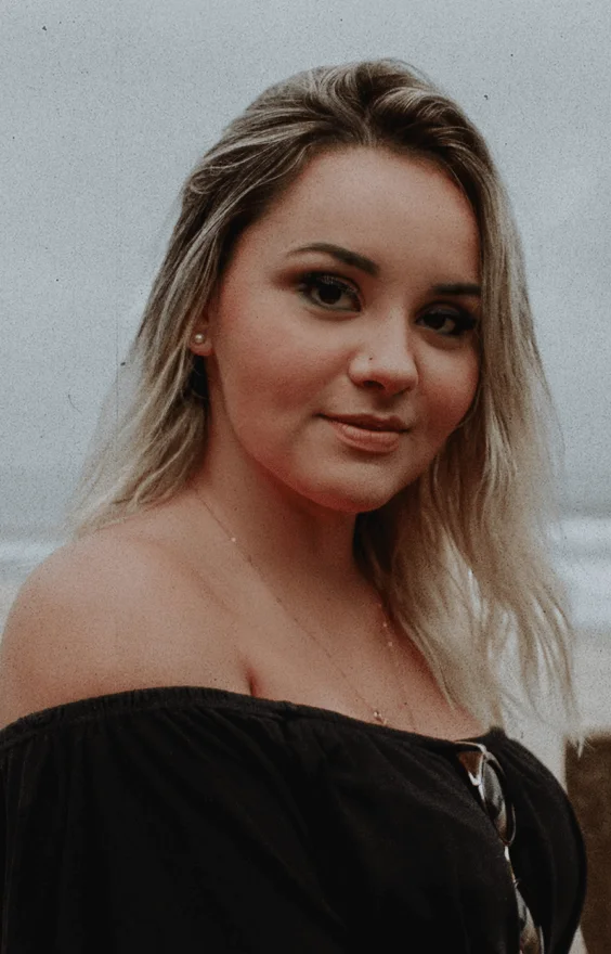 A woman in a black top posing for a photo.