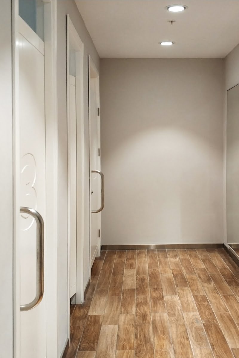 A retail hallway with wooden floors and mirrors undergoing remodeling in a store.