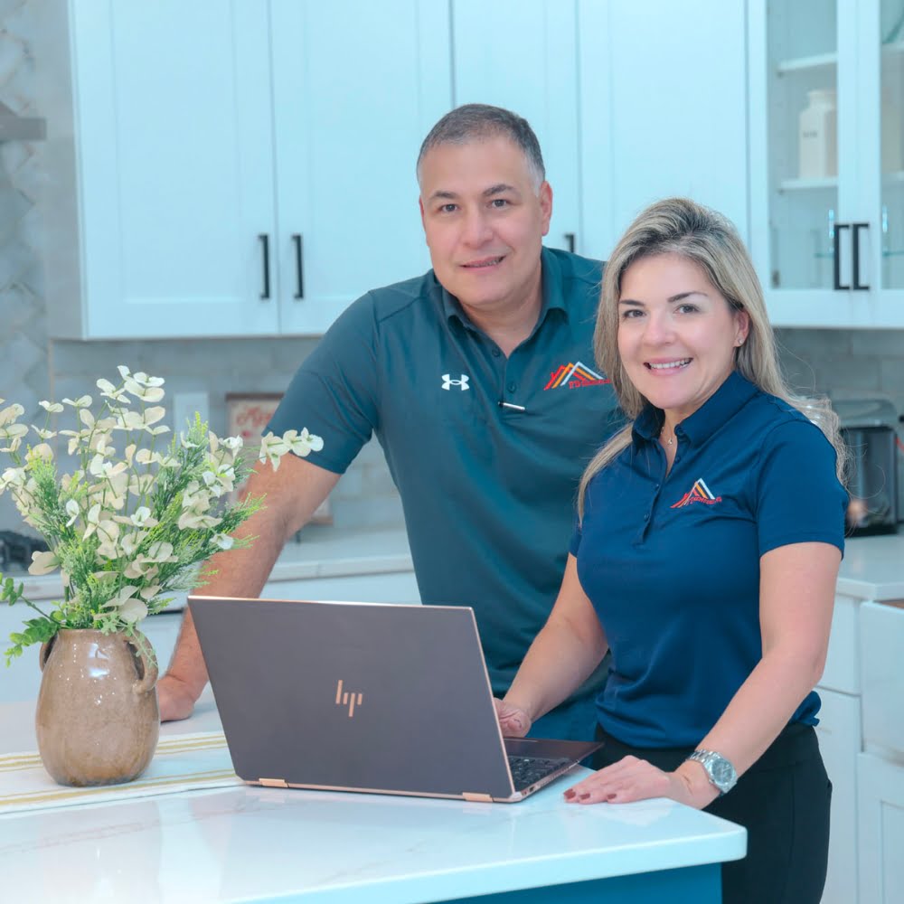About Us - The FD Remodeling team is standing in a kitchen with a laptop, waiting for you to contact them for remodeling services.