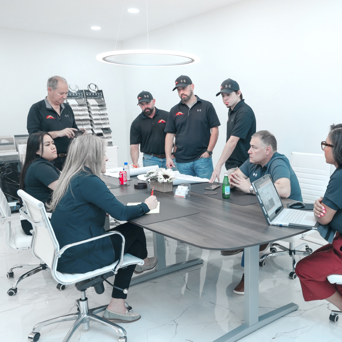 A group of people sitting around a table in an office during a retail store remodeling brainstorming session.