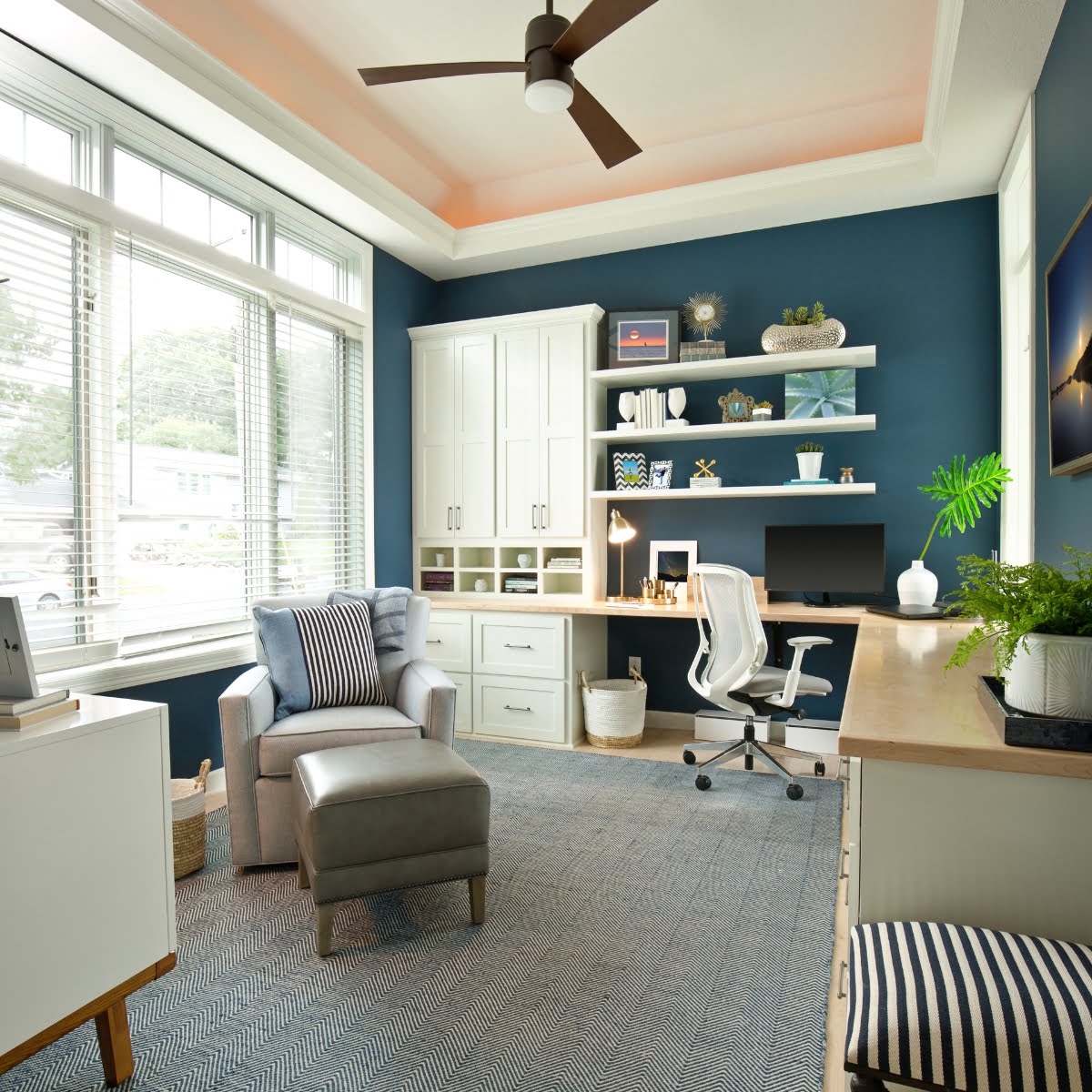 A modern home office space with blue walls and a ceiling fan, perfect for renovations.