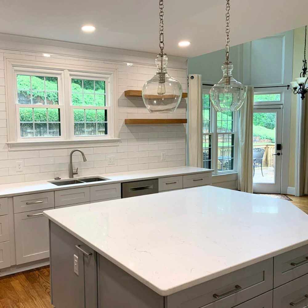 A gray island and white cabinets were designed by FD Marietta home remodeling contractors.
