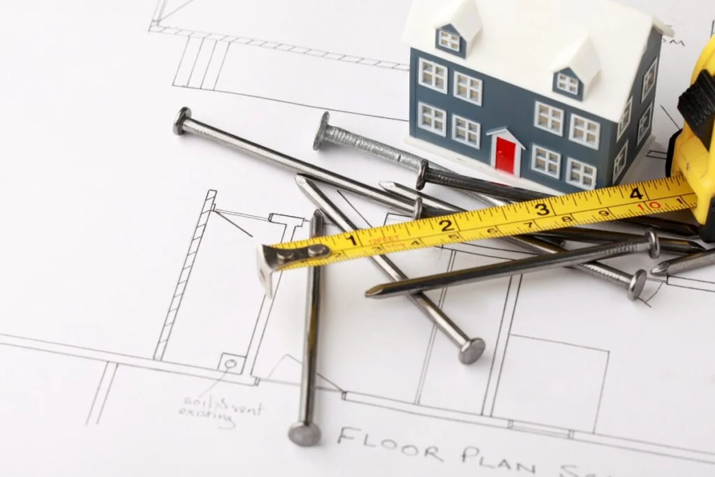 Remodeling Budget Breakdown: How to Make Every Dollar Count 7 A house model adorned with measuring tape, perfect for visualizing your remodeling plans within a budget.