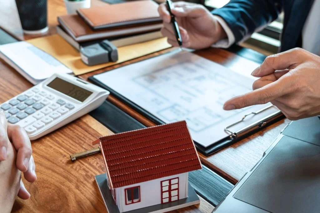 Remodeling Budget Breakdown: How to Make Every Dollar Count 8 A group of people working on a house model while calculating the remodeling budget.