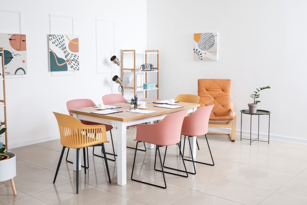 A modern dining room with colorful chairs and a table.