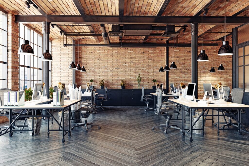 A modern office with wooden floors and brick walls.