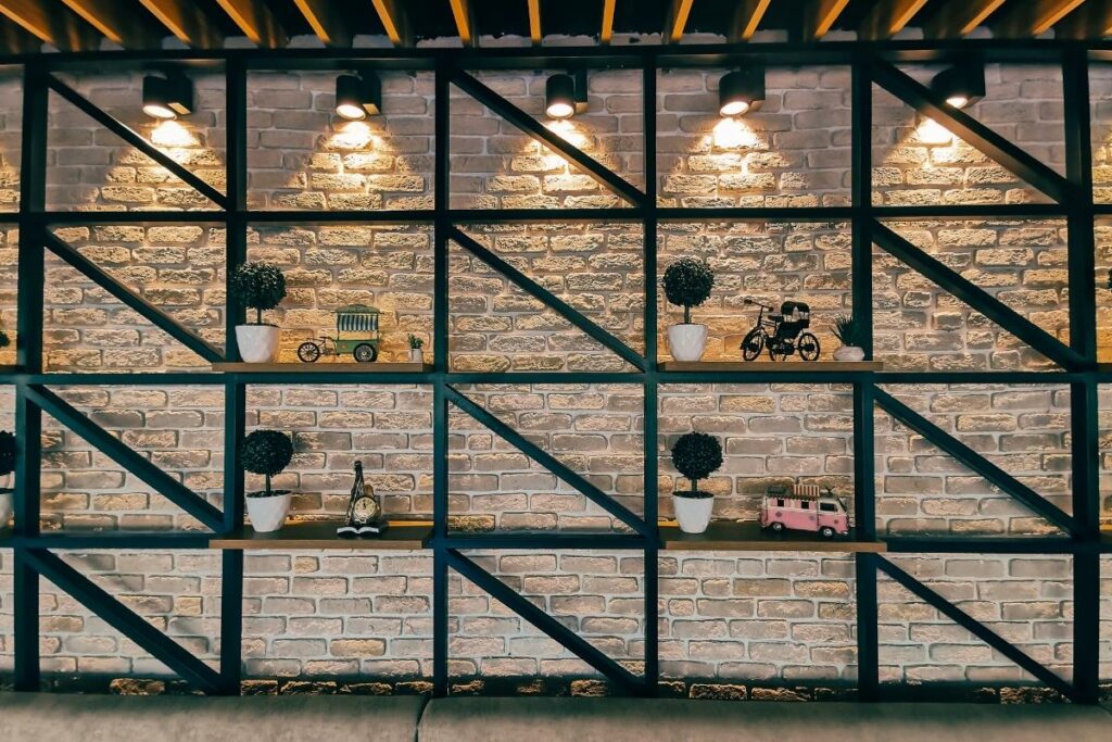 A decorative brick wall with shelves and lights on it.