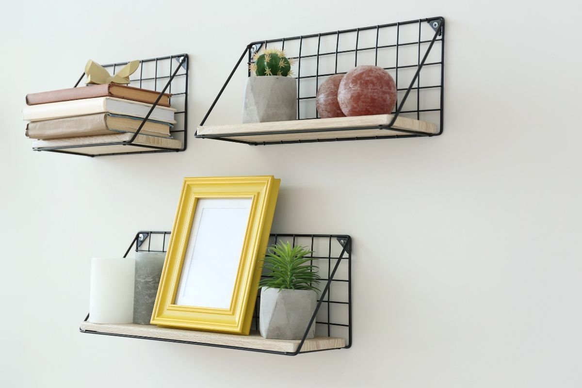 Decorative wall shelves with books and a picture frame on them.