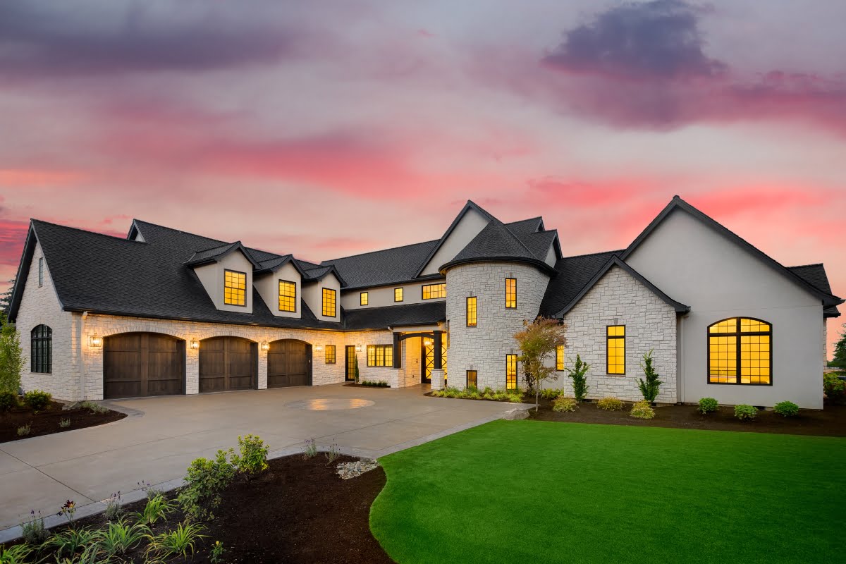 Luxurious suburban home with exterior design featuring illuminated windows at dusk.