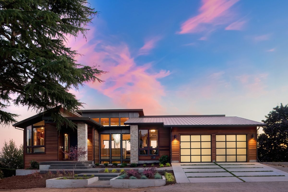 Modern house with vibrant exterior design at twilight with illuminated interior and vibrant sky.
