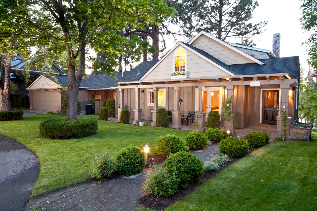Traditional single-story home with manicured landscaping and sophisticated exterior design at dusk.