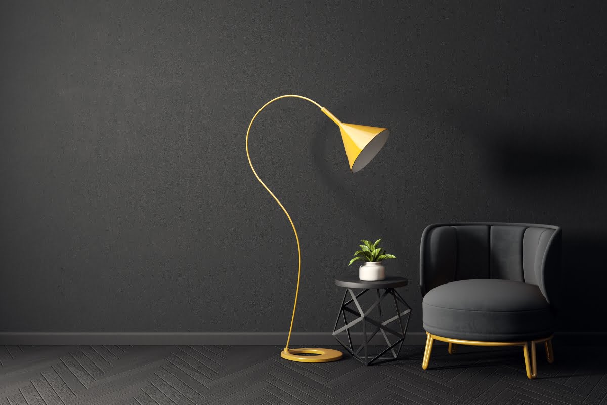 A small yellow lamp next to a black couch in the living room.