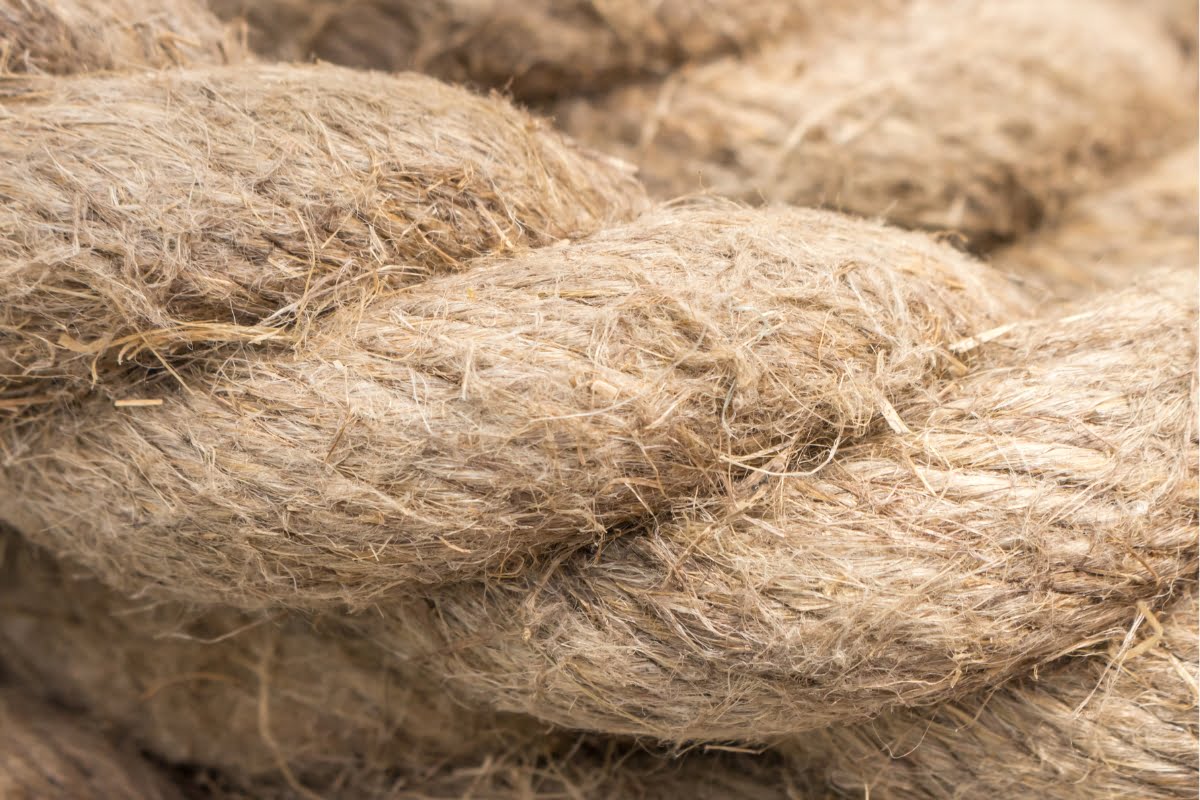 Close-up image of a thick, coiled rope showcasing its rough, fibrous texture, embodying the essence of sustainable building materials.