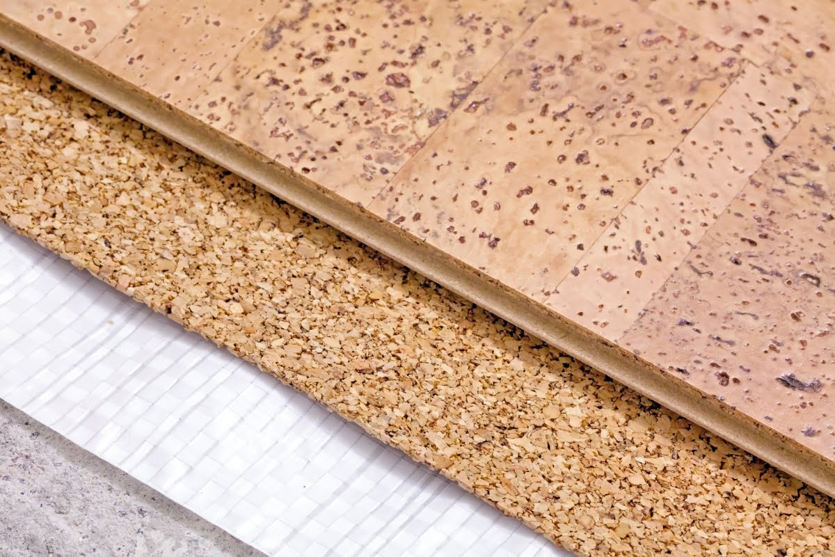 Close-up image of layered cork floor panels, showcasing sustainable building materials, laid out on a textured white surface.