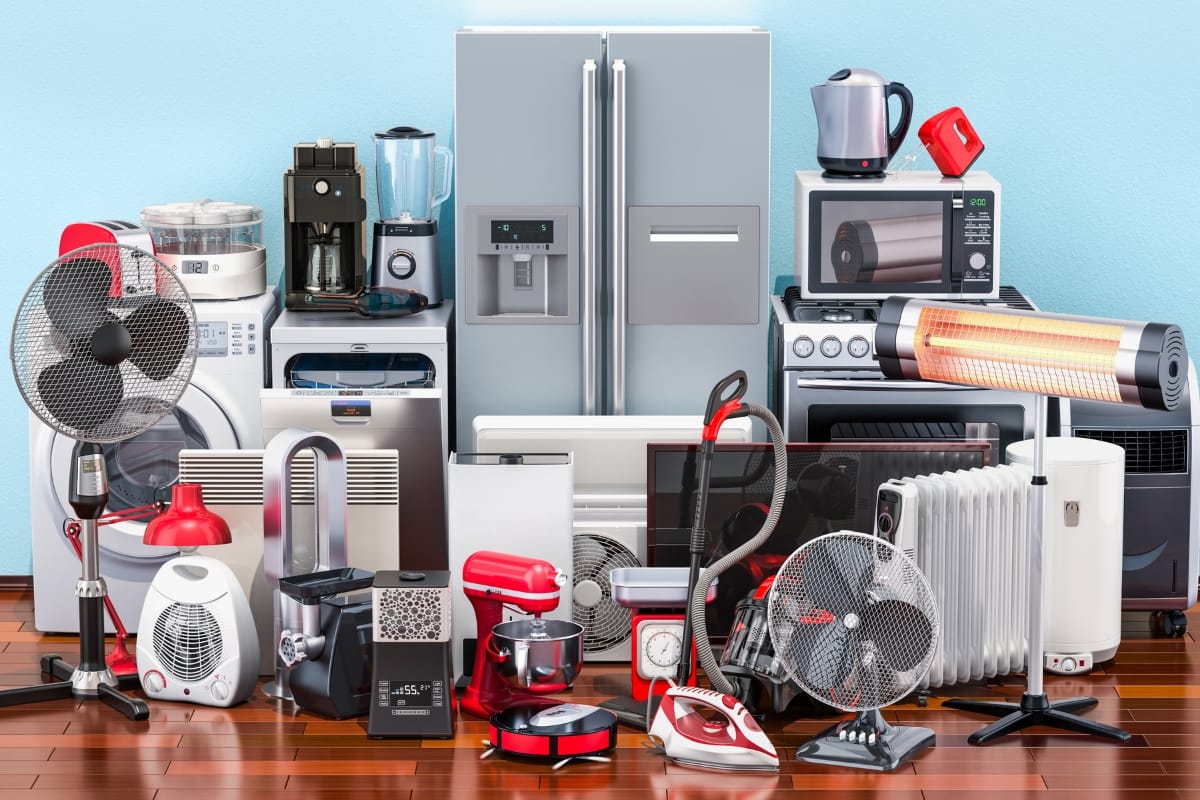 A collection of energy-efficient home appliances, including a refrigerator, microwave, washer, blender, coffee maker, vacuum cleaner, and several fans, thoughtfully arranged on a wooden floor for your remodeling needs.