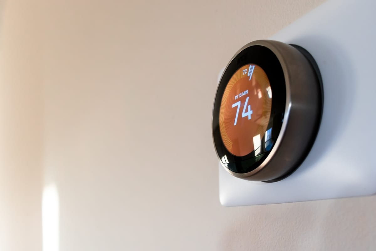 Smart Home Remodeling in Sandy Springs: Top Energy-Efficient Upgrades 3 A smart thermostat mounted on a wall displays the temperature set to 74 degrees Fahrenheit, showcasing the benefits of smart home remodeling.