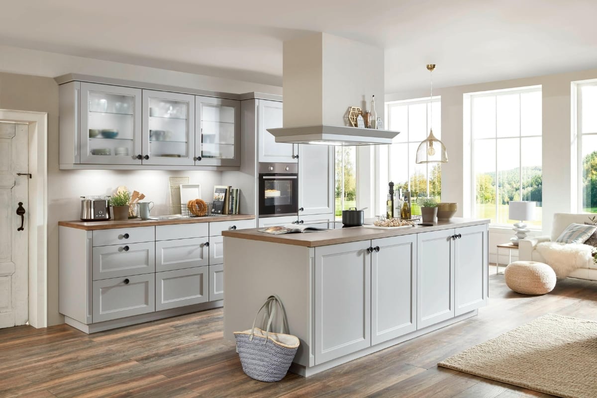 Affordable Kitchen Upgrades: Budget Remodeling Ideas for Smyrna Homes 1 Modern kitchen with gray cabinets, wooden countertops, kitchen island, built-in oven, large windows, and wooden flooring. Natural light fills the space—an inspiring example of affordable kitchen upgrades with stylish touches and functional design.