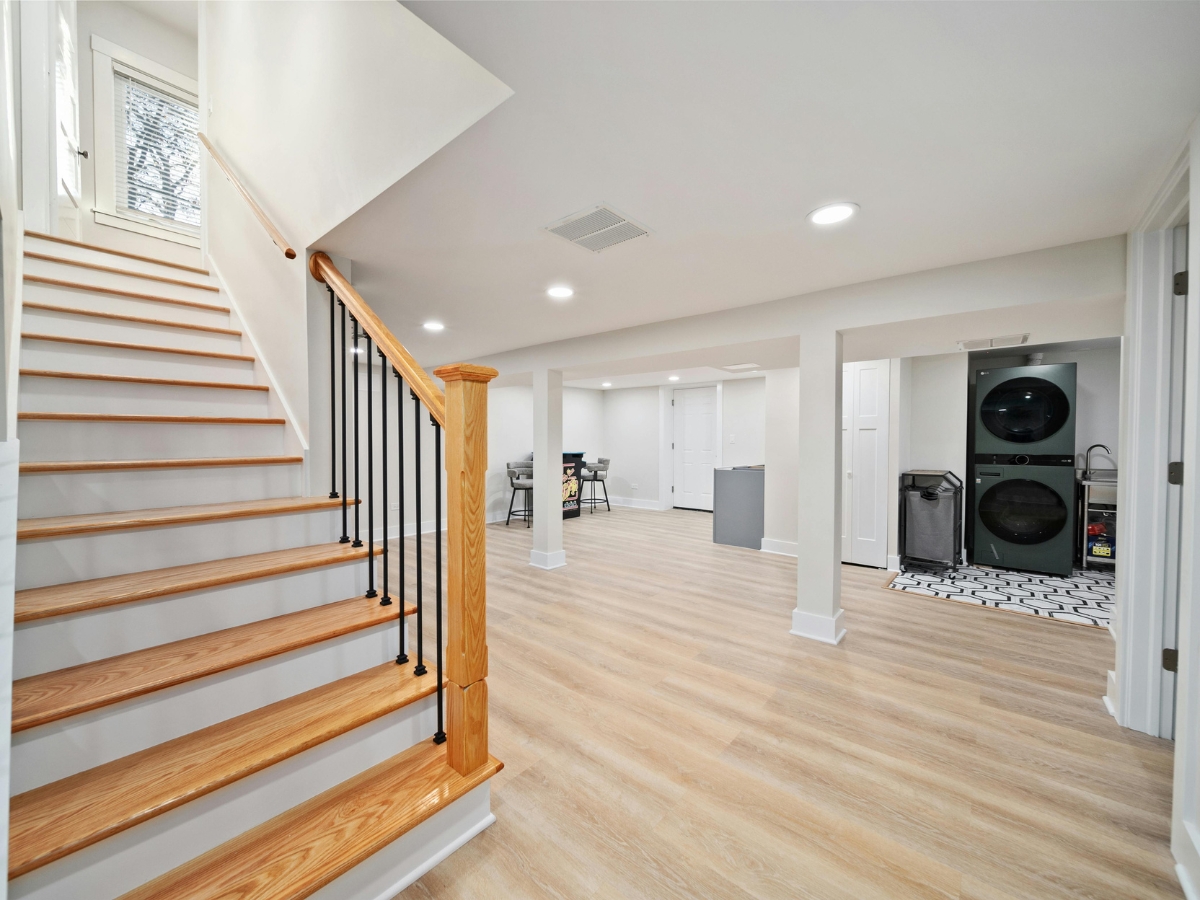 Roswell Basement Remodeling for Holiday Guests: Transform Your Space into a Comfortable Suite 1 Finished basement with light wood flooring, stylish staircase, and laundry area—perfect for Roswell Basement Remodeling for Holiday Guests seeking an inviting open space for seating or gatherings.