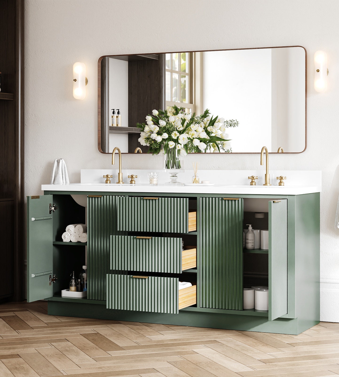 Modern bathroom vanity with sage green cabinets, gold fixtures, double sinks, a large mirror, and drawers and cupboards open to show organized towels and supplies; white flowers decorate the countertop—perfect inspiration for your next bathroom renovation or even a stylish office bathroom remodel.