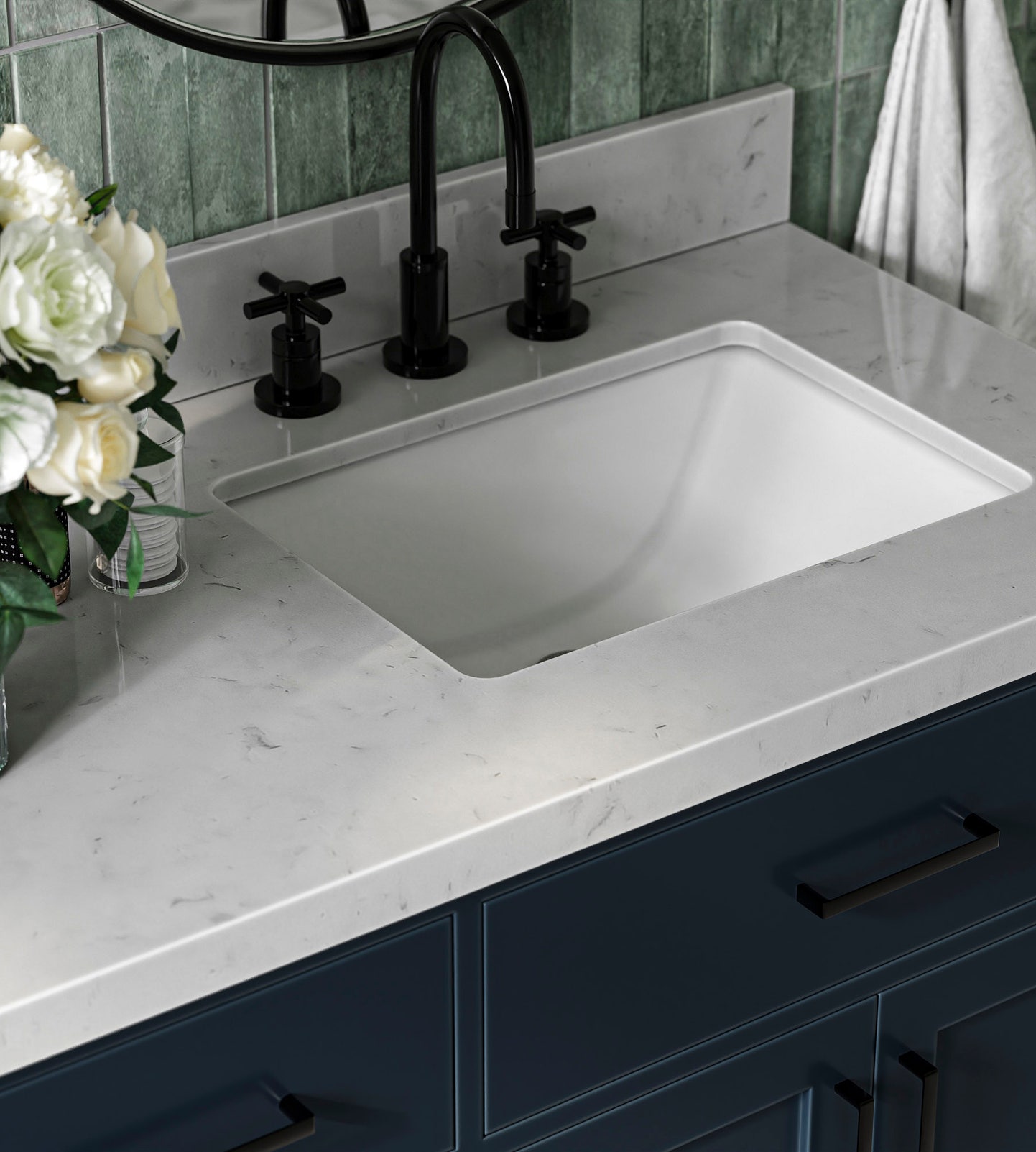 A modern bathroom sink with a white marble countertop, black faucet fixtures, blue cabinetry, and a bouquet of white flowers on the left side adds a touch of elegance—perfect inspiration for your next bathroom renovation.