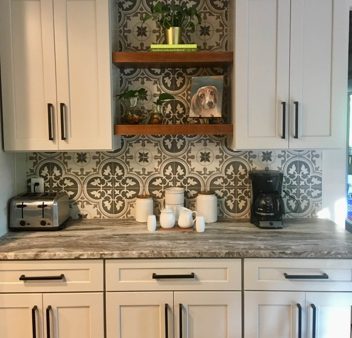A kitchen with white cabinets and a tile backsplash.