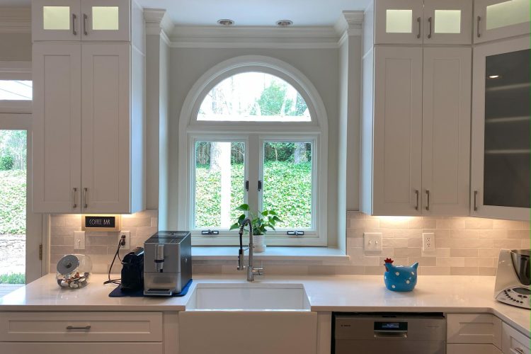 A white kitchen with an arched window.