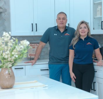 A couple standing in their cozy kitchen at home. A couple standing in their cozy kitchen at home.
