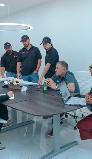 A group of people sitting around a table in an office.