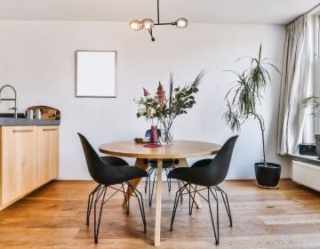 A kitchen with a wooden table and black chairs.